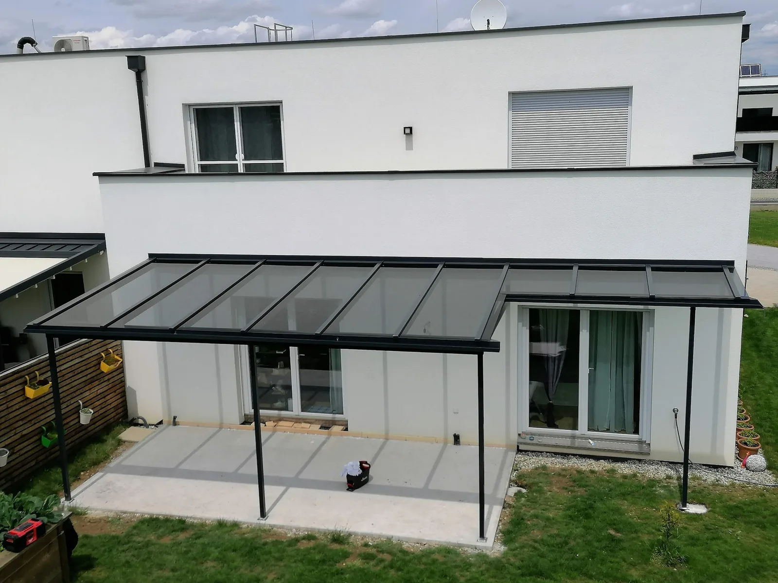 Große Terrassenüberdachung aus Glas an einem Wohnhaus